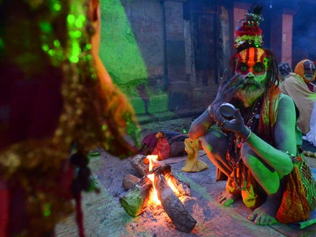 A Nepalese Hindu sadhu paints coloured paste onto his face during the Shivaratri festival in Kathmandu. (AFP photo)