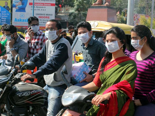 With cases of swine flu increasing, people wear masks donated by a voluntary organisation, in Indore on Tuesday. (Shankar Mourya/HT photo)