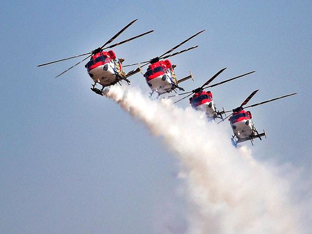 The Indian Air Forces’ helicopter display team ‘Sarang’ performs during the inauguration of the Aero India 2015. (PTI Photo)