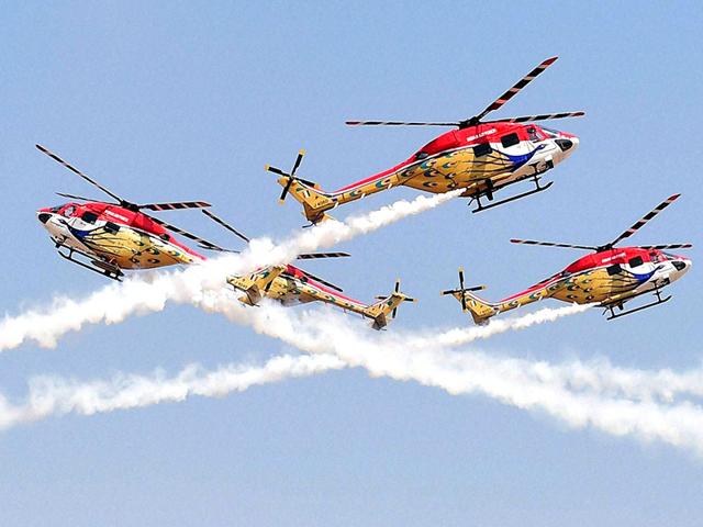 The Indian Air Forces’ helicopter display team ‘Sarang’ performs during the inauguration of the Aero India 2015. (PTI Photo)