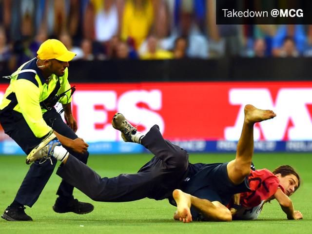A police official tackles a refugee protestor after he runs onto the ground during the match between Australia and England at the Melbourne Cricket Ground on February 14. (AFP Photo)