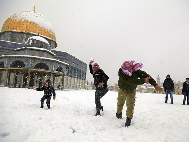 Palestinians throw snowballs in front of the Dome of the Rock in Jerusalem. A heavy winter storm descended on parts of the Middle East on Friday, with snow forcing the closure of all roads leading in and out of Jerusalem and sprinkling Israel's desert with a rare layer of white. (AP photo)