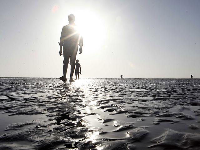 People take a stroll at Juhu beach as mercury levels continued to soar in Mumbai. (Vidya Subramanian/HT photo)