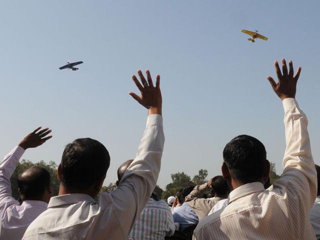 Members of the army microlight expedition team wave during airshow in Bhopal on Sunday. (Mujeeb Faruqui/HT photo)