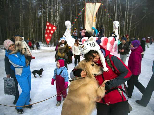 Women play with their dogs during celebrations of Maslenitsa, or Pancake Week, outside the village of Khlyupino, some 50 km (31 miles) west of Moscow, Russia. (AP photo)