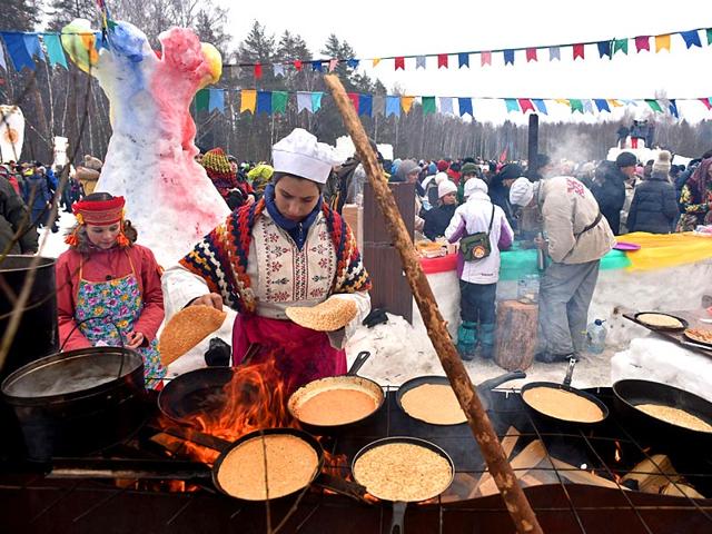A woman prepares pancakes during celebration of Maslenitsa (Shrovetide), a farewell ceremony to winter close to village of Khlyupino about 60 km from Moscow. (AFP photo)