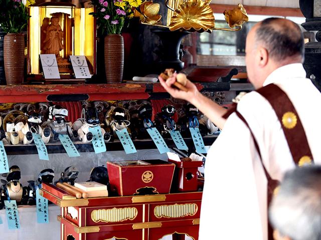 Kofuku-ji temple chief priest Bungen Oi (R) offers a prayer during the funeral for 19 Sony's pet robot AIBOs at the Kofuku-ji temple. (AFP PHOTO)