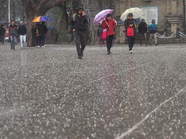 People walking at Ridge during hailstorm in Shimla. Santosh Rawat/HT
