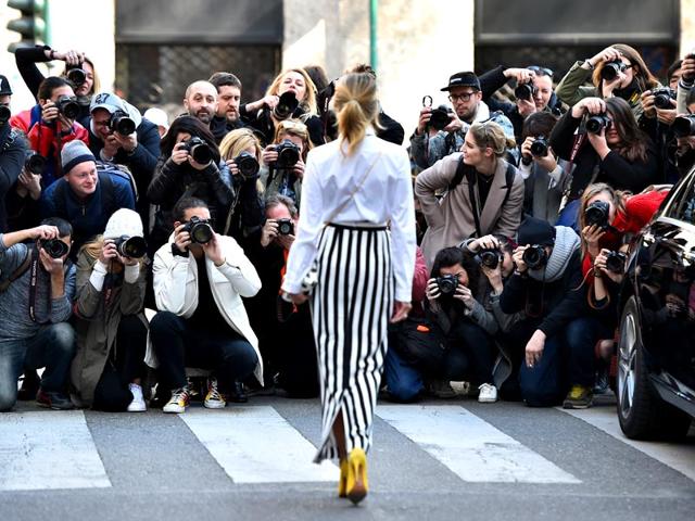 A vertical stripe teamed with a high-waisted skirt elongate the legs, while the yellow shoes keep things modern. 
