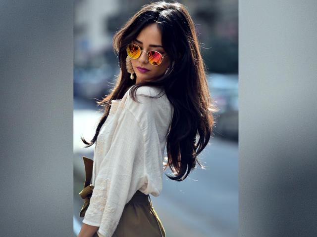 A simple cheese-cloth shirt lets the accessories do the talking here, in the form of oversized pearl earrings and reflective 60s-style sunnies. 