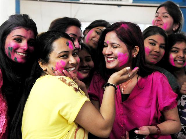 Young girls smear the faces of their friends with vibrant colors on the occasion of Holi, in Bhopal on Thursday. (Mujeeb Faruqui/HT photo)