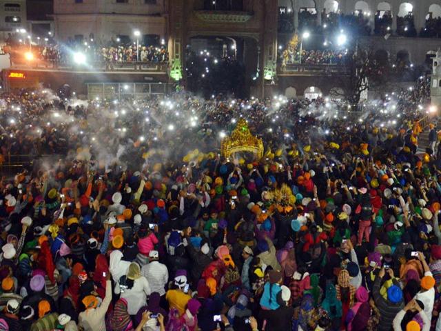 Sikh devotees spray perfume on the Palki Sahib which carries the Sikh holy books to mark the Hola Mohalla festival at the Golden Temple in Amritsar. Sameer Sehgal/HT