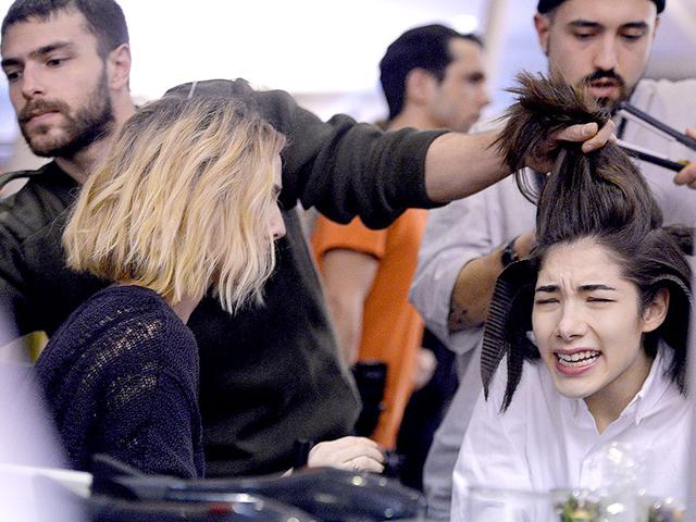 You've seen runway pictures, but what goes down backstage at Paris Fashion Week? Here are some revealing shots. Olympia Le Tan: Ouch! The hairstyling looks painful behind the scenes at the Olympia Le Tan show. (Photos: AFP)