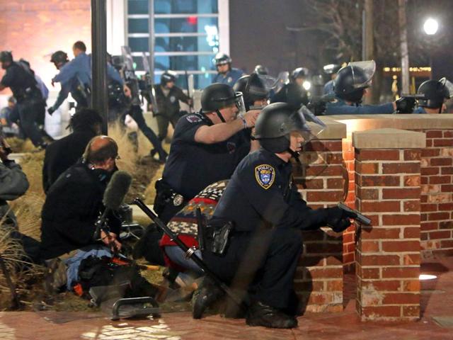 Police-take-cover-after-two-officers-were-shot-while-standing-guard-in-front-of-the-Ferguson-Police-Station-on-Thursday-March-12-2015-AP-Photo Police-take-cover-after-two-officers-were-shot-while-standing-guard-in-front-of-the-Ferguson-Police-Station-on-Thursday-March-12-2015-AP-Photo
