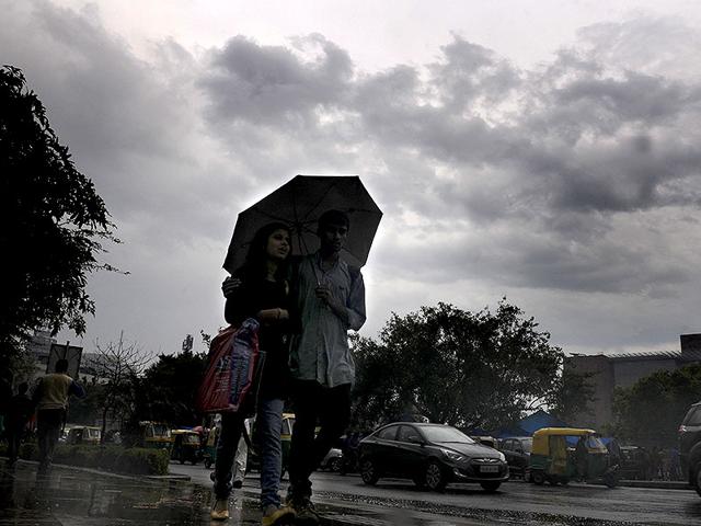 People enjoying pleasant weather after a spell of rain at Connaught Place, in New Delhi. (HT Photo/Sonu Mehta)