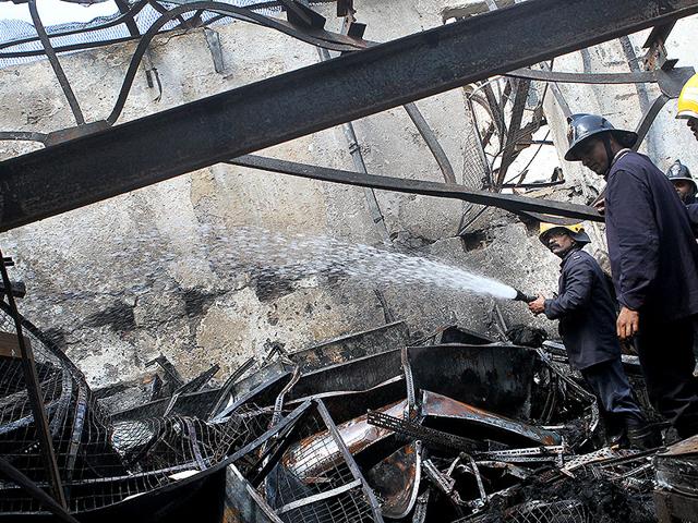 Fire brigade members douse fire at a socks factory in Jogeshwari that caught fire on Sunday night, in Mumbai. (Arijit Sen/HT photo)