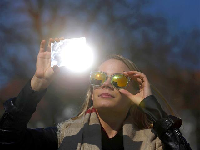 A woman watches a partial solar eclipse in Budapest. (Reuters)