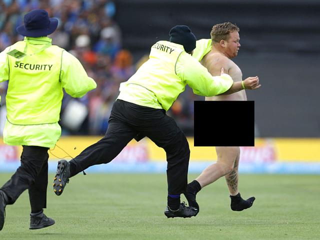 Security personnel chase a streaker who invaded the pitch during the Cricket World Cup match between New Zealand and Sri Lanka in Christchurch, February 14, 2015. REUTERS