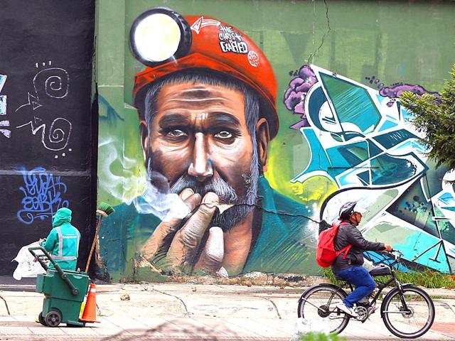A man rides on a cycle path past walls painted with graffiti and murals, in Bogota, Colombia. Murals in Bogota grew in part out of tragedy, when police shot and killed graffiti artist Diego Felipe Becerra in 2011 as he painted his trademark Felix the Cat. (AP photo)