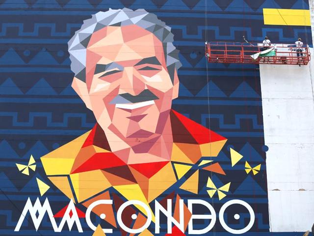 Street artists paint a mural of late writer Gabriel Garcia Marquez on the side of a building, in Bogota, Colombia. (AP photo)