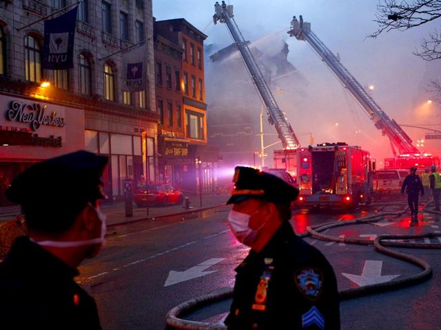 Police-officers-stand-guard-while-firefighters-battle-a-blaze-at-a-commercial-and-residential-block-in-New-York-s-East-Village Police-officers-stand-guard-while-firefighters-battle-a-blaze-at-a-commercial-and-residential-block-in-New-York-s-East-Village