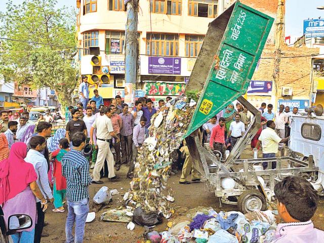East-Delhi-Municipal-Corporation-workers-dump-garbage-on-the-road-in-Shahdara-in-protest-against-non-paywent-of-salaries-on-time-Sonu-Mehta-HT-Photo