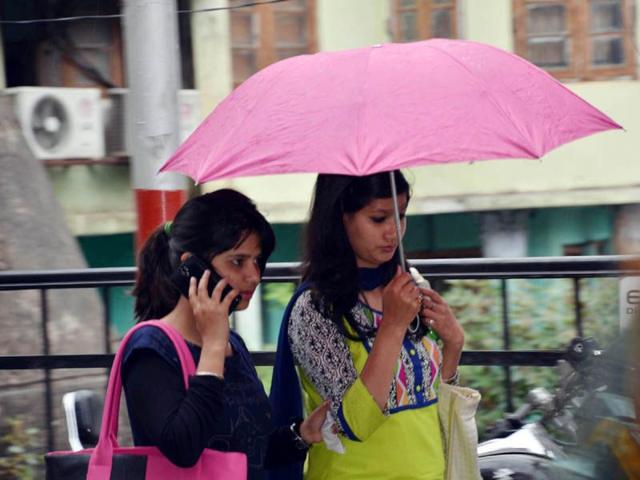 Girls walking in rain in Mandi.HT/Photo