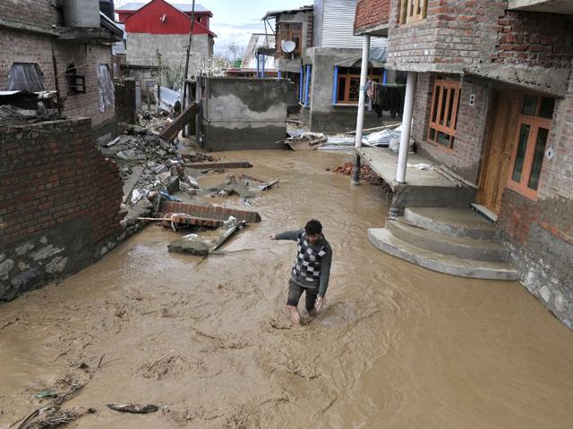 A Kashmiri man makes his way through a flooded area following incessant rain in Srinagar. Waseem Andrabi/HT