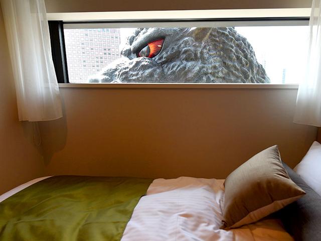 A life-size Godzilla head is seen through a window of the "Gozilla View Room" of Hotel Gracery Shinjuku at Kabukicho shopping district in Tokyo. AFP/Toru Yamanaka A life-size Godzilla head is seen through a window of the "Gozilla View Room" of Hotel Gracery Shinjuku at Kabukicho shopping district in Tokyo. AFP/Toru Yamanaka