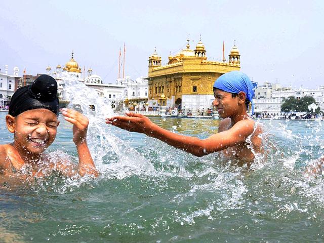Devotees taking bath in the holy Sarovar and paying obeisance at the Golden Temple in Amritsar on the occasion of Baisakhi. (PTI Photo)