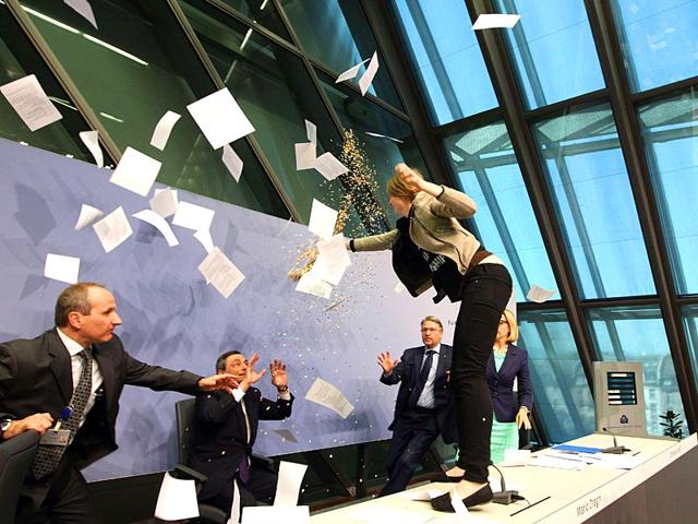 A-woman-throws-papers-and-confetti-as-she-interrupts-a-press-conference-by-Mario-Draghi-C-president-of-the-European-Central-Bank-ECB-following-a-meeting-of-the-Governing-Council-in-Frankfurt-Main-Germany-AFP-Photo A-woman-throws-papers-and-confetti-as-she-interrupts-a-press-conference-by-Mario-Draghi-C-president-of-the-European-Central-Bank-ECB-following-a-meeting-of-the-Governing-Council-in-Frankfurt-Main-Germany-AFP-Photo