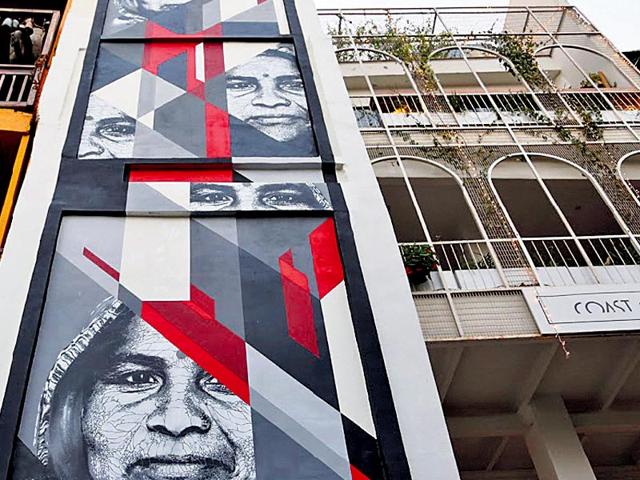 Joao Samina, Portugal: Celebrating the warmth and the calm of an anonymous old Indian woman, the artist takes a portrait by Indian photographer Ved Upadhyay and merges it with his own style. One can spot this piece on the wall of a retail outlet in Hauz Khas Village. Joao Samina, Portugal: Celebrating the warmth and the calm of an anonymous old Indian woman, the artist takes a portrait by Indian photographer Ved Upadhyay and merges it with his own style. One can spot this piece on the wall of a retail outlet in Hauz Khas Village.