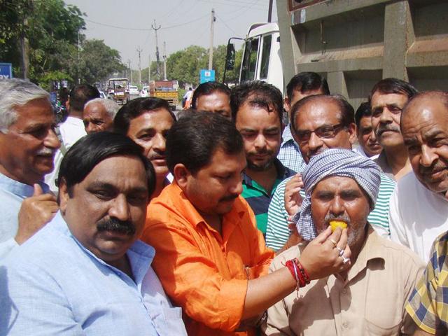 Haryana-chief-minister-s-OSD-Amarendra-Singh-orange-shirt-offering-sweets-to-differently-abled-rickshaw-puller-Om-Prakash-after-inauguration-of-Rs-1-30-cr-road-carpeting-project-in-Karnal-on-Sunday-HT-Photo Haryana-chief-minister-s-OSD-Amarendra-Singh-orange-shirt-offering-sweets-to-differently-abled-rickshaw-puller-Om-Prakash-after-inauguration-of-Rs-1-30-cr-road-carpeting-project-in-Karnal-on-Sunday-HT-Photo