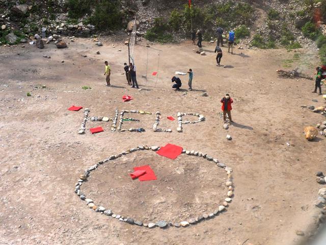 Foreign-trekkers-and-Nepalese-guides-are-pictured-alongside-a-HELP-sign-constructed-with-white-stones-from-an-Indian-Army-helicopter-at-Machha-Khola-in-northern-central-Gorkha-district-on-April-29-2015-AFP-Photo