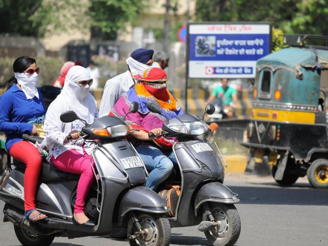 Commuters covering their faces to protect themselves from the scorching heat.HT