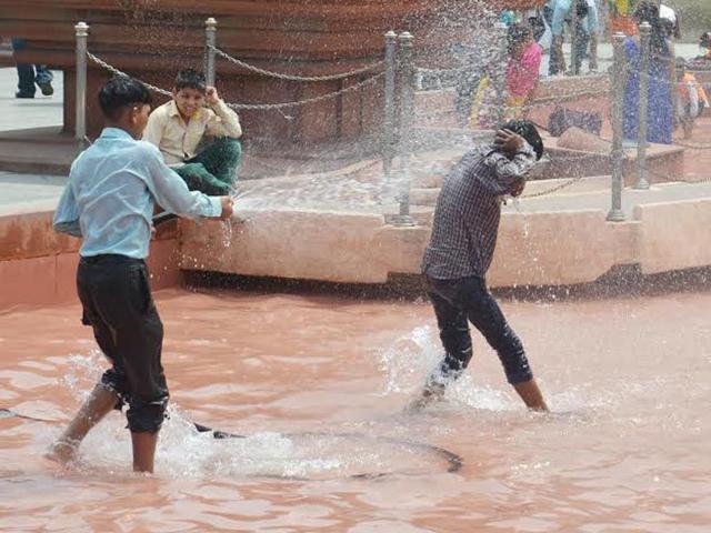 Boys playing with water in order to get some relief from heat.