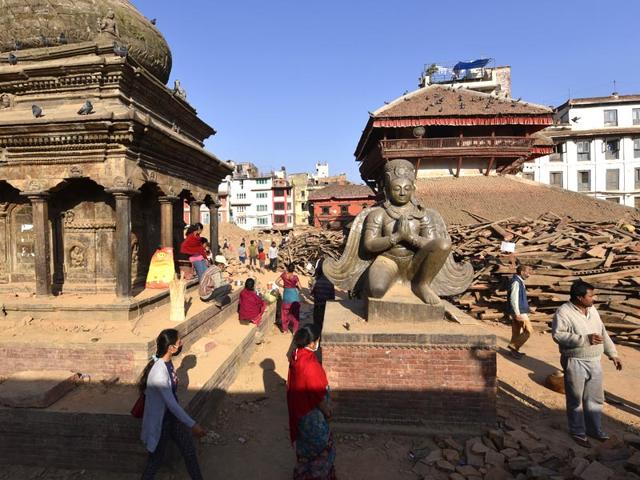 A statue of King Pratap Malla in a praying posture flanked by the devastation caused by the killer temblor, in Kathmandu. (Gurinder Osan/HT Photo)