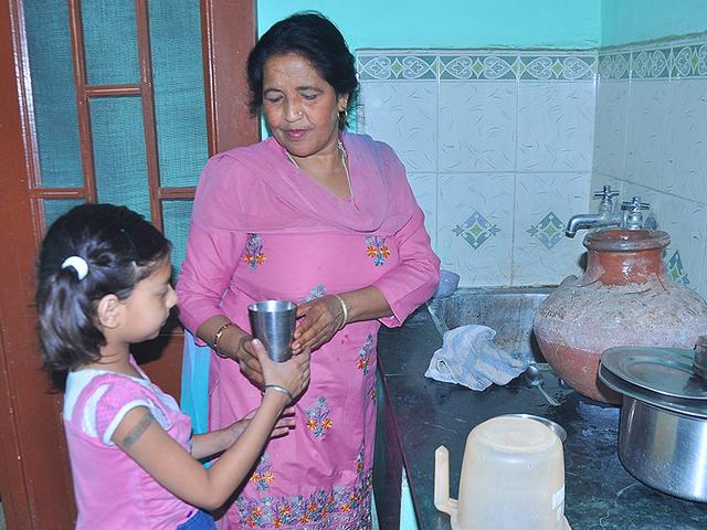 A-member-of-the-staff-offering-a-glass-of-water-to-a-girl-at-a-creche-in-Mani-Majra-Sant-Arora-HT-Photo A-member-of-the-staff-offering-a-glass-of-water-to-a-girl-at-a-creche-in-Mani-Majra-Sant-Arora-HT-Photo