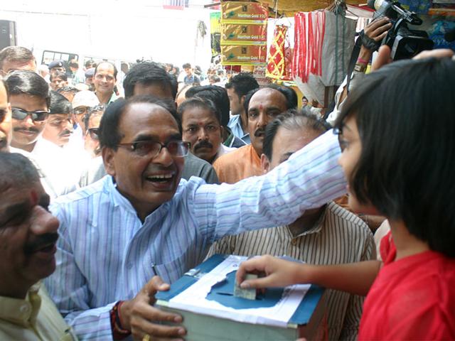 Chief minister Shivraj Singh Chouhan appreciates a girl for donating for Nepal earthquake victims, in Bhopal on Tuesday. (Bidesh Manna/HT photo)
