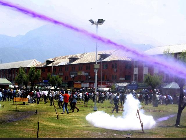 A Kashmiri daily wage government employee running as police spray water cannon and fire tear gas shells during a protest march in Srinagar. Waseem Andrabi/HT
