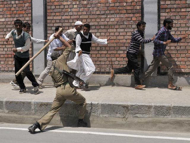 Police beating a Kashmiri daily wage government employee during a protest march in Srinagar. Waseem Andrabi/HT