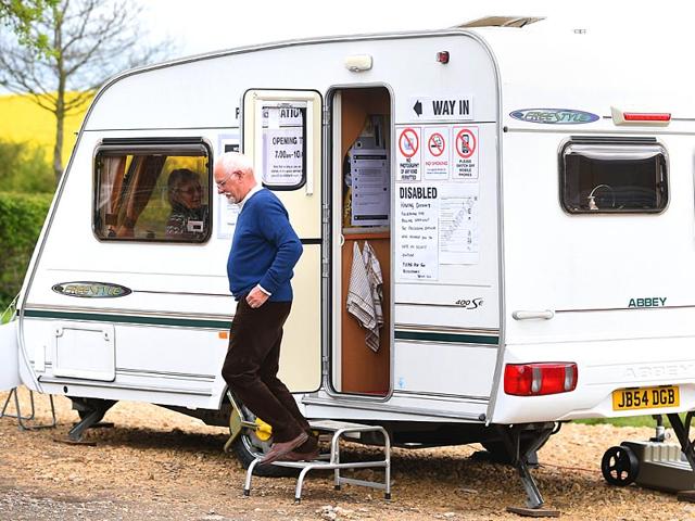 A man leaves after casting his vote in a caravan which is being used as a polling station on Grange Farm in Garthorpe, England. (AP Photo)