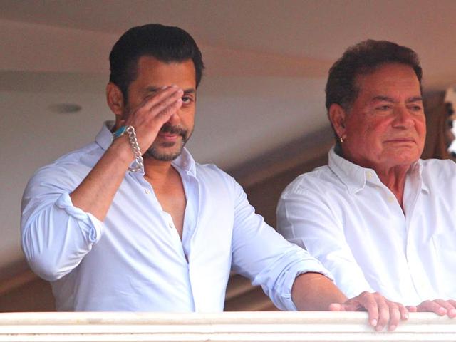 Bollywood actor Salman Khan greets fans from the balcony of his home, with his father Salim Khan standing by his side in Mumbai. (AP Photo)