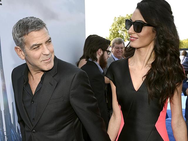 Never too far from each other: George Clooney's lawyer wife Amal wows the world media once again in a frilly pink and black dress. (Reuters photo) 