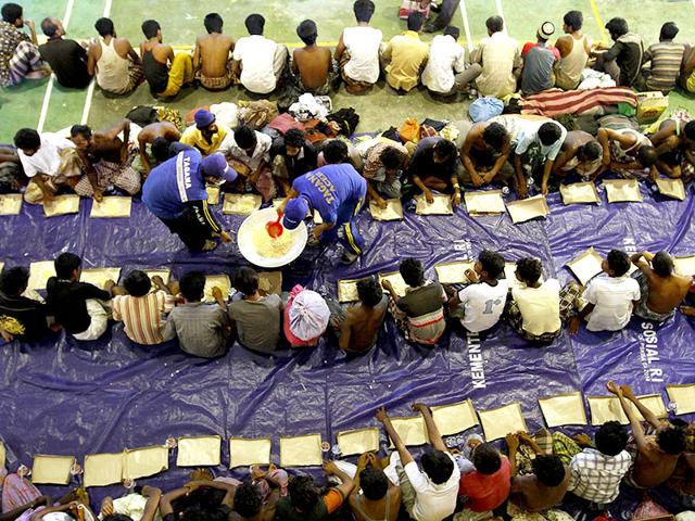 Indonesian Rescue Team members distribute food to migrants believed to be Rohingya inside a shelter after they were rescued from boats, in Lhoksukon in Indonesia's Aceh Province. REUTERS Indonesian Rescue Team members distribute food to migrants believed to be Rohingya inside a shelter after they were rescued from boats, in Lhoksukon in Indonesia's Aceh Province. REUTERS