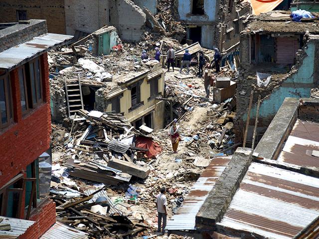 People walk along the debris of collapsed houses after a fresh 7.3-magnitude earthquake in Nepal. (Reuters Photo)