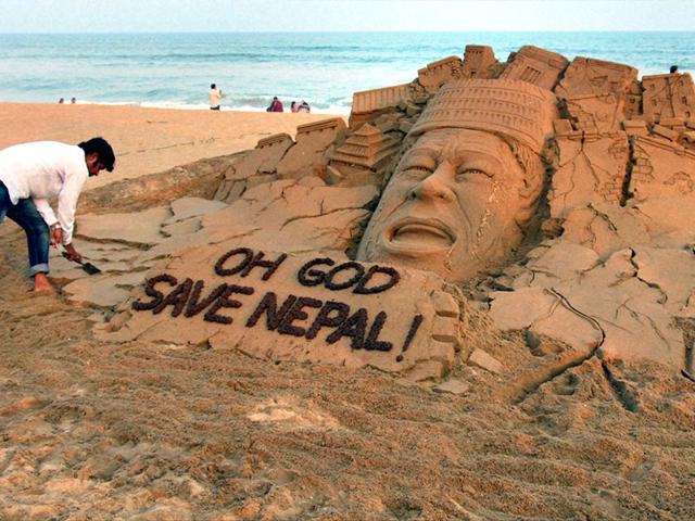 Sand artist Sudarsan Pattnaik creates a sand sculpture on Nepal earthquake at Puri beach in Odisha. (PTI Photo)