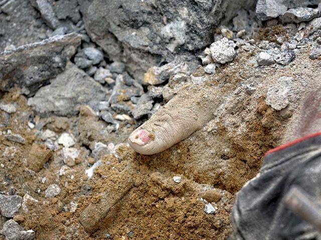 A hand is seen in the quake debris after a fresh temblor hit Nepal. (Burhaan Kinu/ HT Photo)