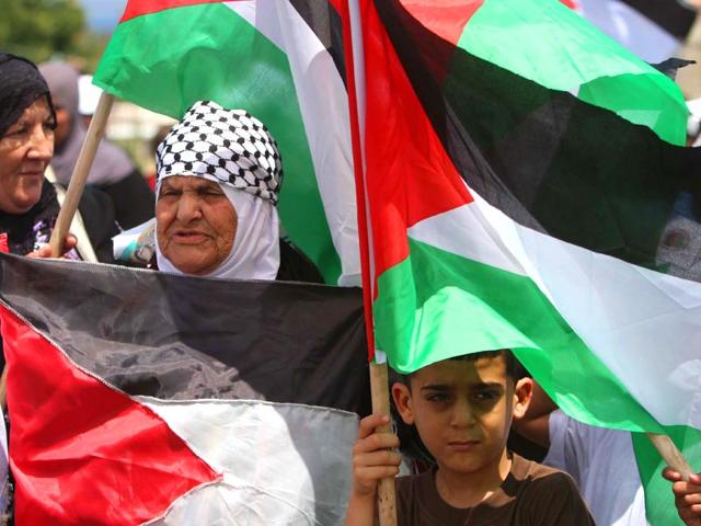 Palestinians living in Lebanon wave Palestinian flags during a protest marking the 67th anniversary of the 'Nakba'. (AP Photo)
