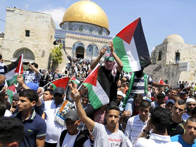 Palestinians wave flags after Friday prayers during a protest to mark Nakba day on May 15, 2015, near the Dome of the Rock on the compound known to Muslims as Noble Sanctuary and to Jews as Temple Mount, in Jerusalem's Old City. (Reuters)